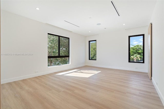 spare room with plenty of natural light and light hardwood / wood-style flooring