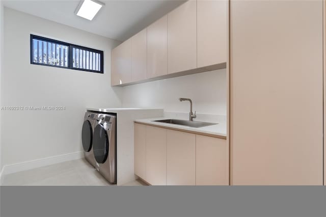 laundry room with washing machine and dryer, sink, and cabinets