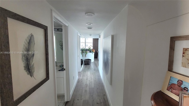 hallway with light hardwood / wood-style floors