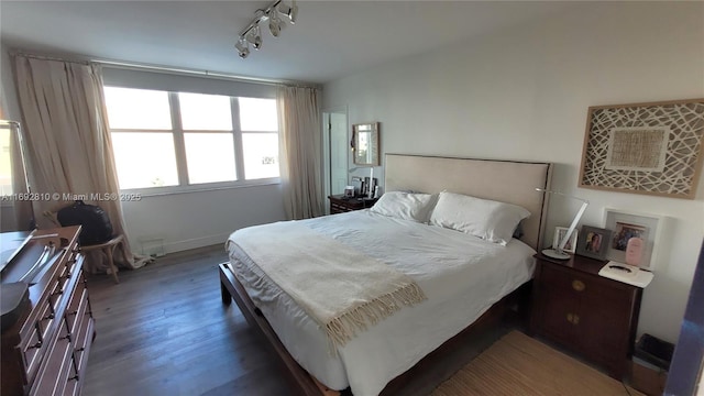 bedroom featuring dark hardwood / wood-style floors and rail lighting