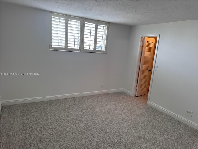 spare room with a textured ceiling and carpet floors