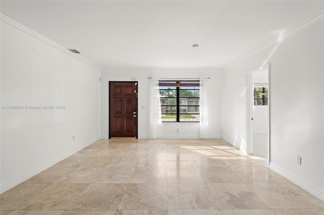 spare room with baseboards and crown molding