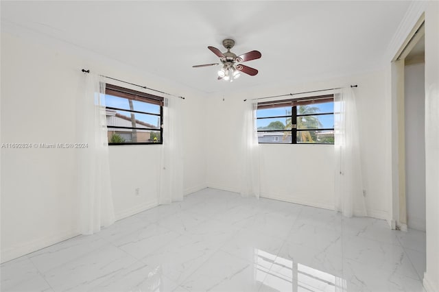 empty room featuring ornamental molding, a wealth of natural light, and ceiling fan