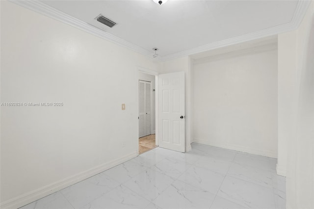 spare room with marble finish floor, baseboards, crown molding, and visible vents