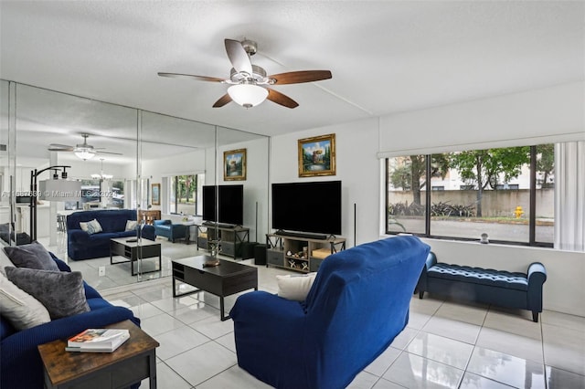 living room with a textured ceiling, light tile patterned flooring, and ceiling fan