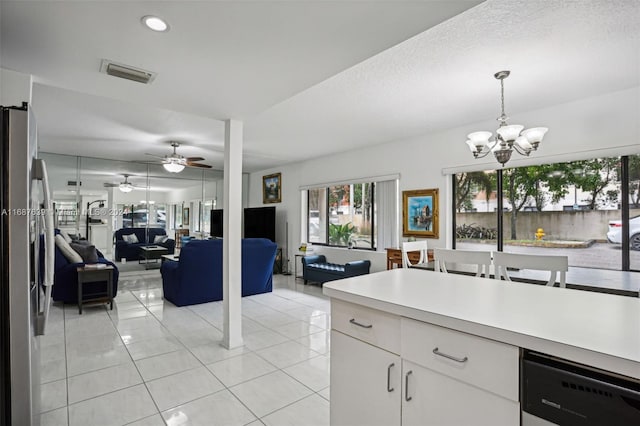 kitchen featuring white cabinetry, appliances with stainless steel finishes, light tile patterned floors, hanging light fixtures, and ceiling fan with notable chandelier