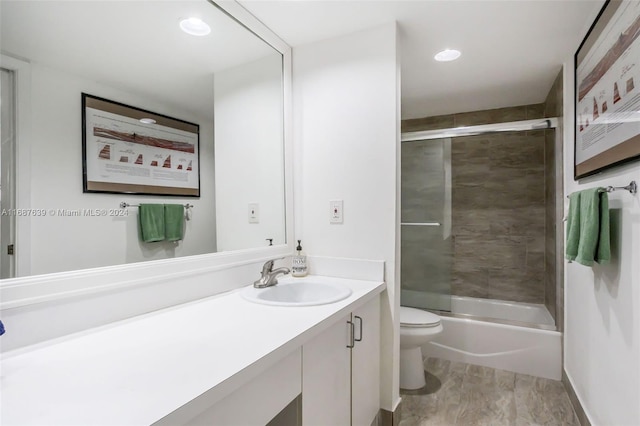 full bathroom featuring enclosed tub / shower combo, vanity, and toilet