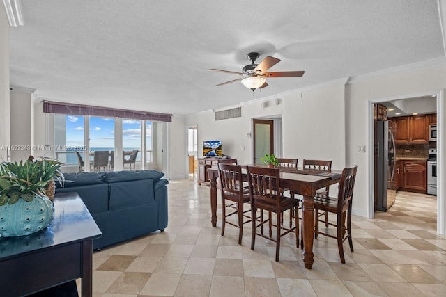 dining room with ceiling fan, ornamental molding, and a textured ceiling