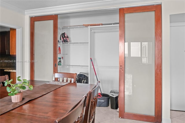 dining room with ornamental molding and light tile patterned flooring