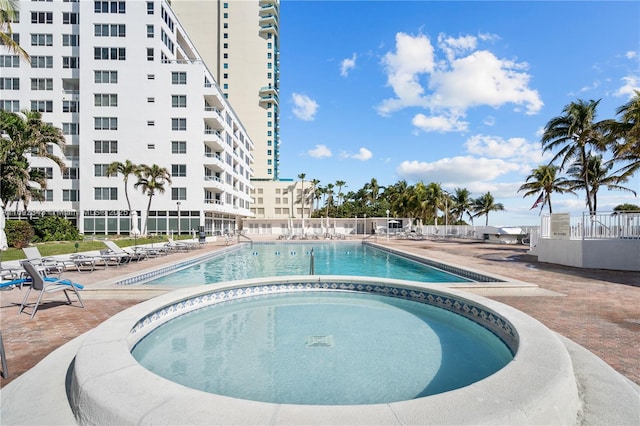 view of pool with a patio area and a hot tub