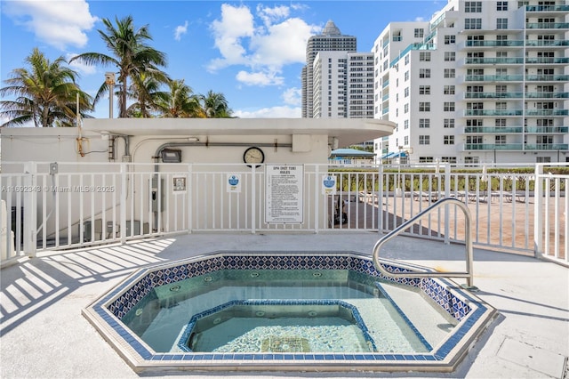 view of swimming pool featuring a hot tub