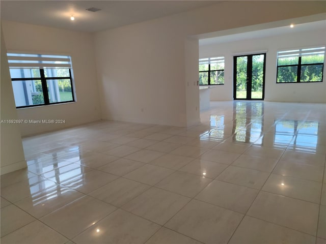 tiled empty room featuring french doors