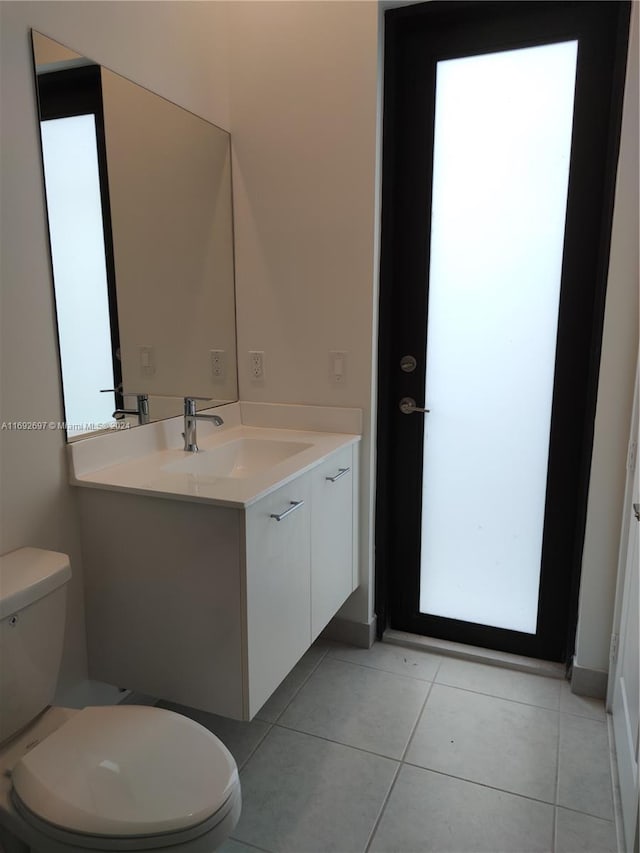 bathroom featuring vanity, tile patterned floors, and toilet