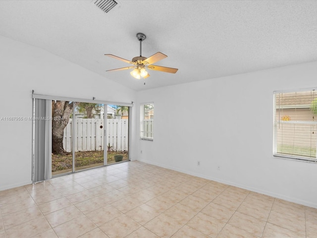 unfurnished room with ceiling fan, light tile patterned floors, a textured ceiling, and vaulted ceiling