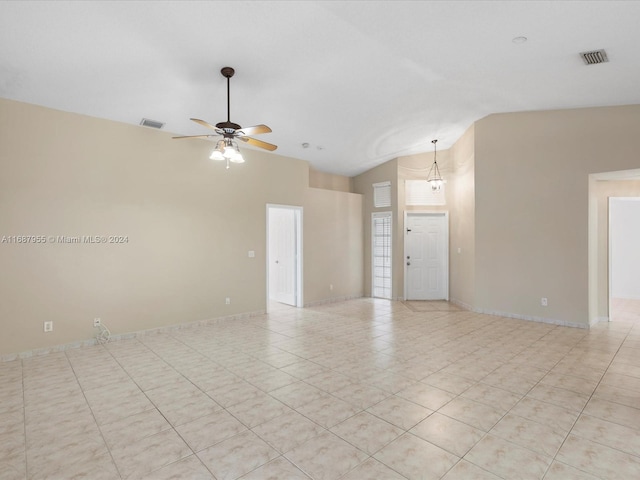 empty room with ceiling fan, lofted ceiling, and light tile patterned floors