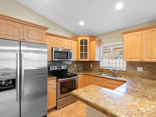 kitchen featuring sink, vaulted ceiling, light brown cabinetry, tasteful backsplash, and stainless steel appliances