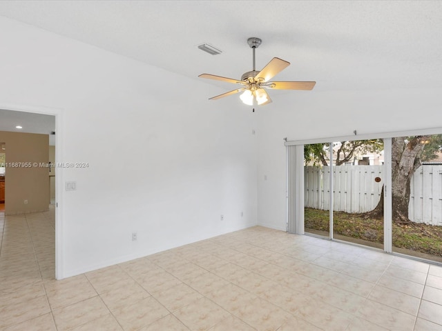 tiled spare room with ceiling fan and vaulted ceiling