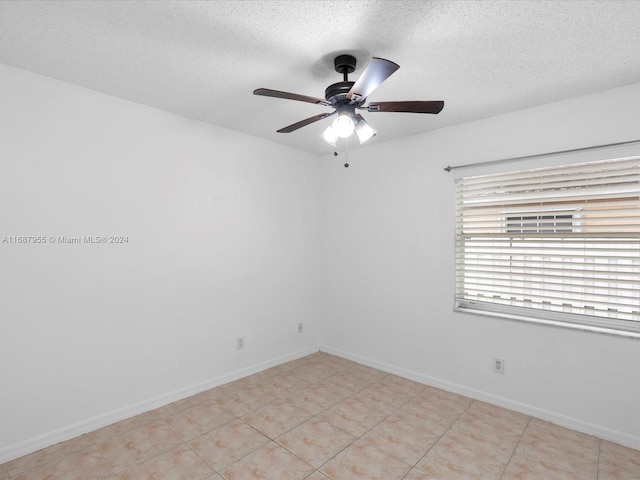 tiled spare room with ceiling fan and a textured ceiling