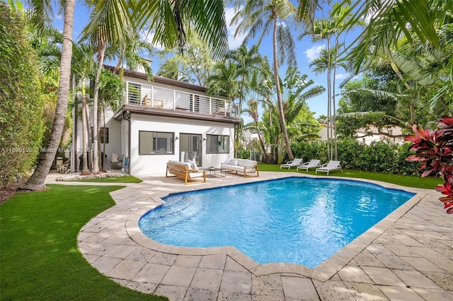 view of swimming pool with outdoor lounge area, a lawn, and a patio