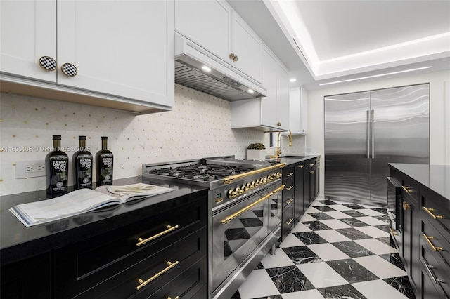 kitchen featuring white cabinetry, high end appliances, custom range hood, and sink