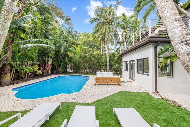 view of pool featuring an outdoor living space, a yard, and a patio