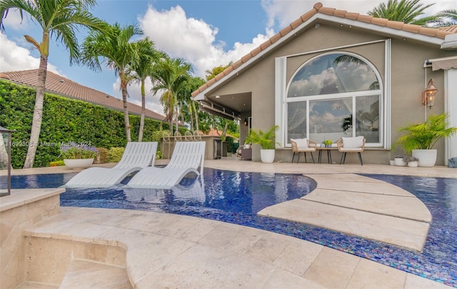 view of pool with an outbuilding and a patio