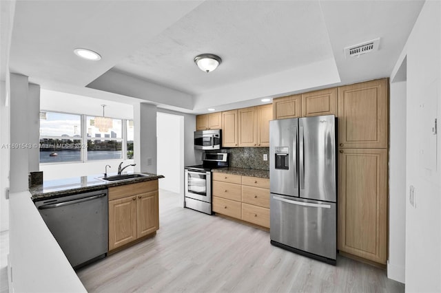 16570 NE 26th Ave Unit 2A, North Miami Beach, FL 33160 - kitchen featuring stainless steel appliances, a raised ceiling, a sink, light wood finished floors, and recessed lighting