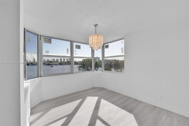 16570 NE 26th Ave Unit 2A, North Miami Beach, FL 33160 - empty room featuring a chandelier, wood finished floors, baseboards, and a water view