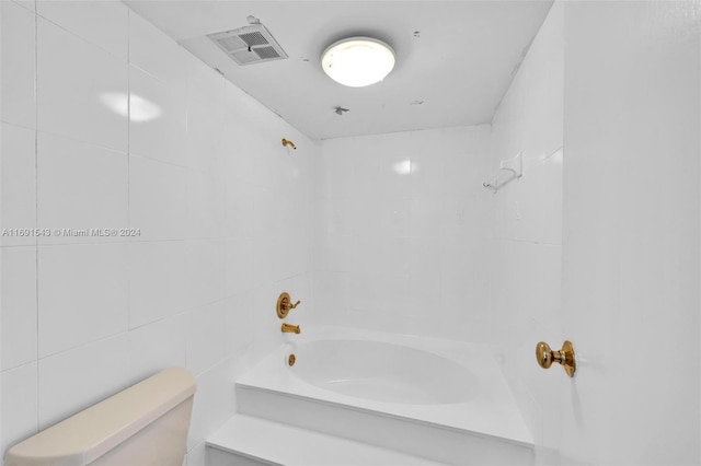 16570 NE 26th Ave Unit 2A, North Miami Beach, FL 33160 - bathroom featuring toilet, bathing tub / shower combination, and tile walls