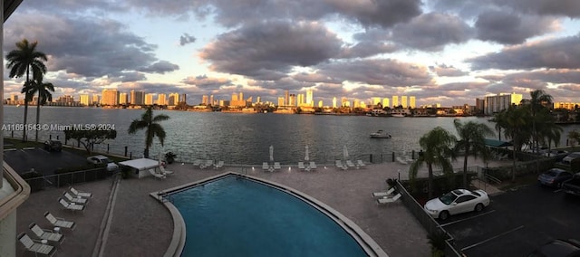 16570 NE 26th Ave Unit 2A, North Miami Beach, FL 33160 - pool at dusk with a skyline view, a water view, and a community pool