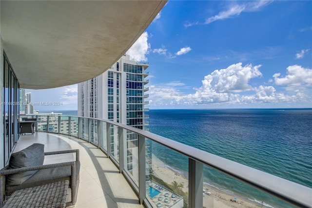 balcony featuring a water view and a beach view