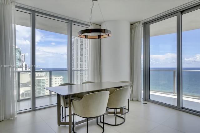 dining room featuring a wealth of natural light, a water view, and floor to ceiling windows