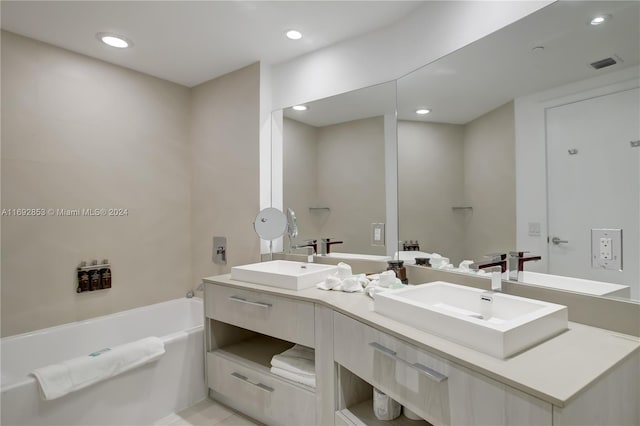 bathroom with a bathtub, vanity, and tile patterned flooring