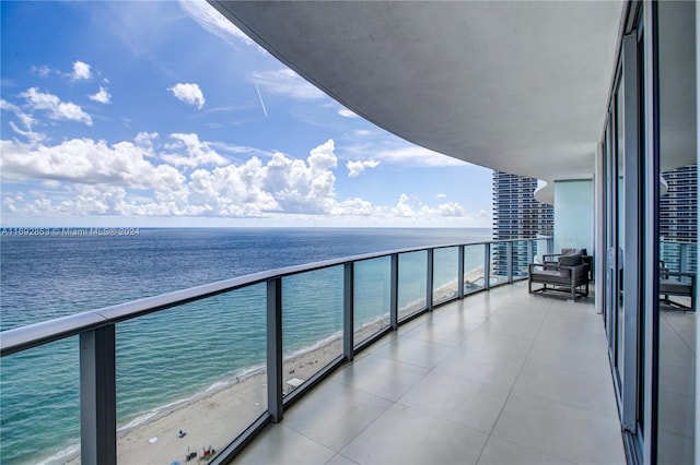 balcony featuring a beach view and a water view