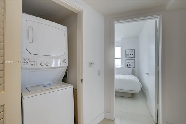 washroom with light tile patterned flooring and stacked washer / dryer