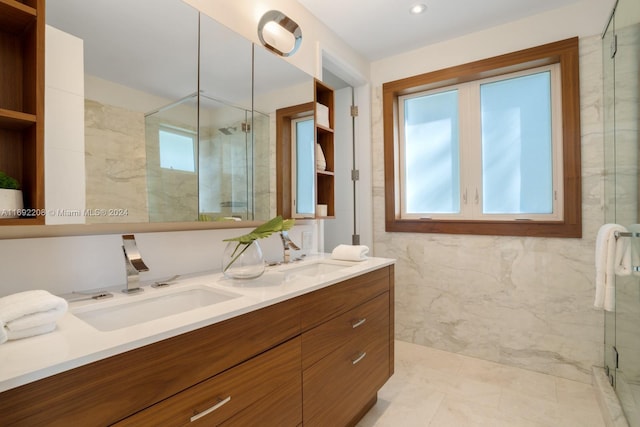 bathroom featuring tile patterned flooring, vanity, an enclosed shower, and tile walls