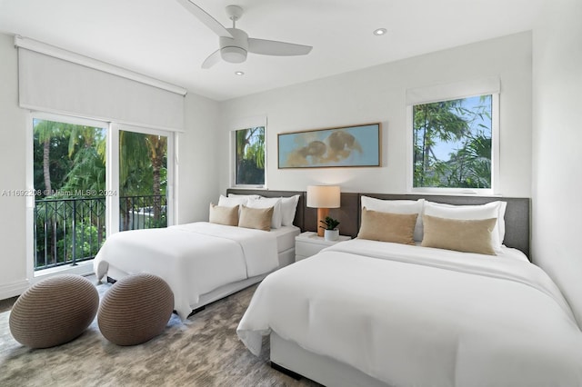 bedroom featuring hardwood / wood-style floors, ceiling fan, access to outside, and multiple windows