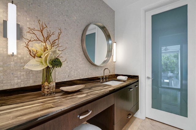 bathroom featuring tasteful backsplash, tile patterned floors, and vanity