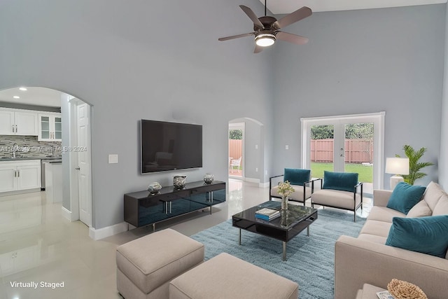 living room featuring french doors, light tile patterned floors, high vaulted ceiling, sink, and ceiling fan