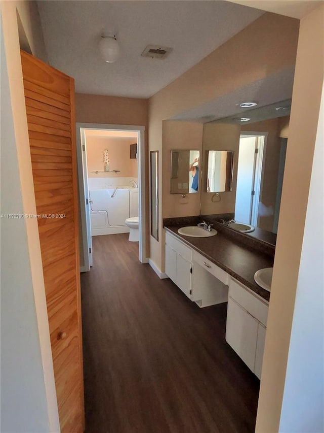 bathroom with vanity, wood-type flooring, a washtub, and toilet