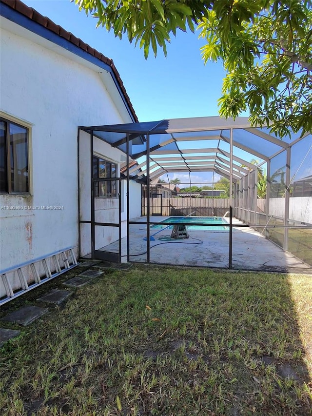 view of yard with a patio, a fenced in pool, and glass enclosure