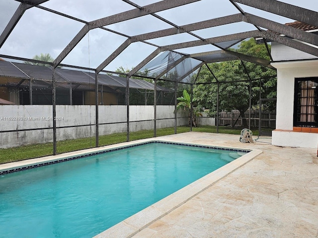 view of swimming pool featuring a lanai and a patio