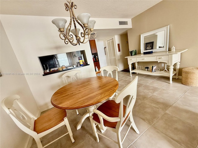 dining area featuring a textured ceiling, lofted ceiling, a chandelier, and tile patterned floors