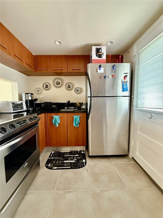 kitchen with light tile patterned flooring and appliances with stainless steel finishes