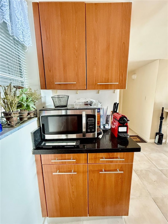 kitchen featuring light tile patterned floors and dark stone countertops