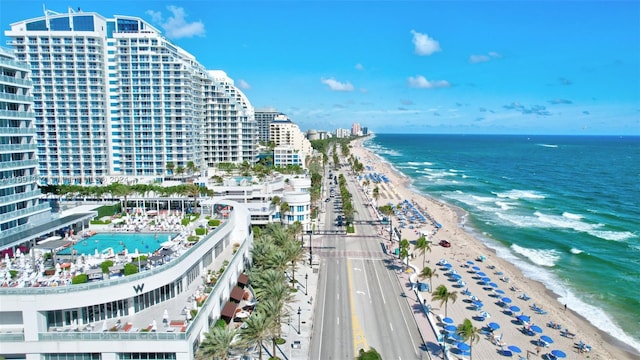 birds eye view of property featuring a water view and a beach view