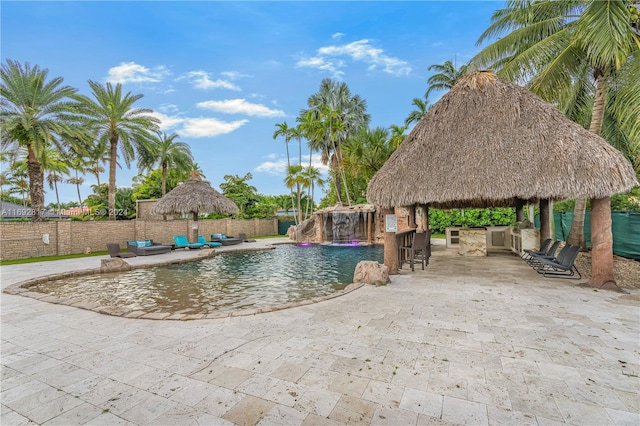 view of swimming pool featuring an outdoor bar, a gazebo, and pool water feature