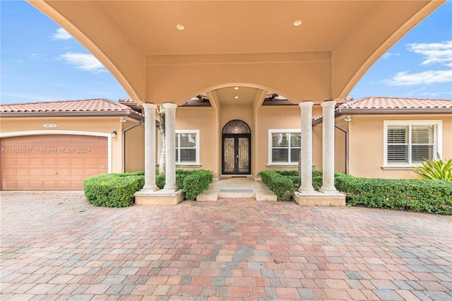 entrance to property featuring a garage and french doors