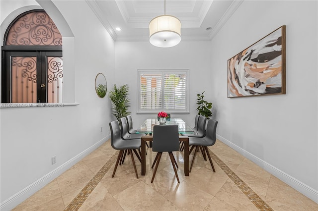 dining room with a tray ceiling and ornamental molding