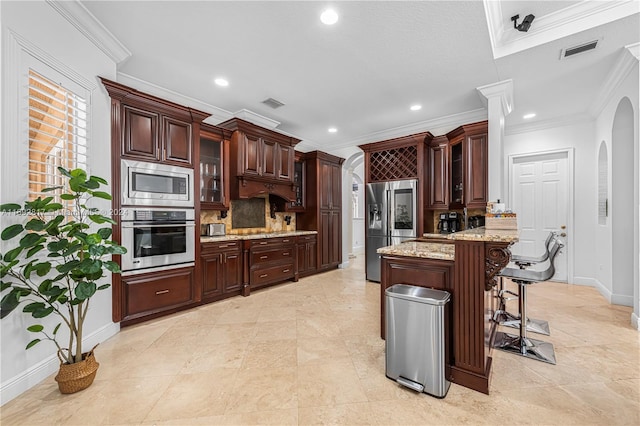 kitchen with stainless steel appliances, ornamental molding, a kitchen breakfast bar, backsplash, and a center island